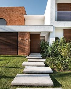 a modern house with stone steps leading up to the front door and side yard area