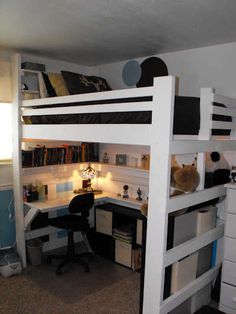 a loft bed with desk underneath it in a room filled with furniture and bookshelves