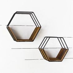 two metal and wood hexagonal wall shelves on white painted walls, one with black wire