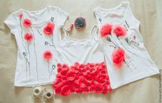 three t - shirts with red flowers on them are laying next to some tape and scissors