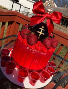 a red cake with candles and a cross on top