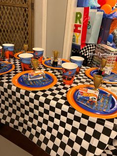 a table set up for a birthday party with plates, cups and condiments