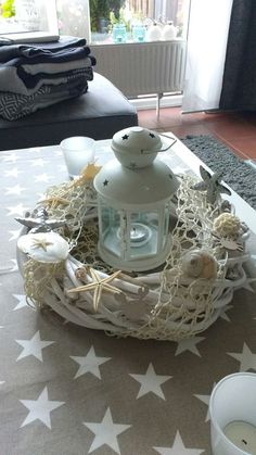 a table topped with a white candle and star shaped decorations