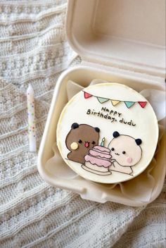 a birthday cake with two bears on it in a plastic container next to a toothbrush