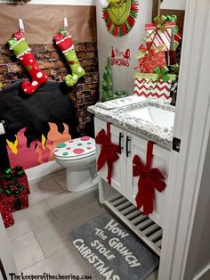 a bathroom decorated for christmas with stockings and stocking on the wall, toilet paper wrapped in red and green