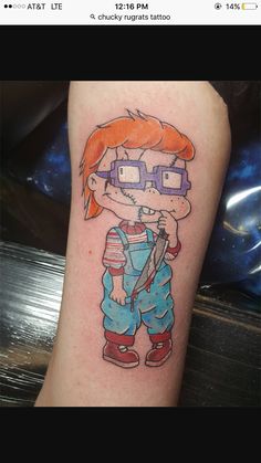 a cartoon character tattoo on the leg of a person with glasses and an orange hair