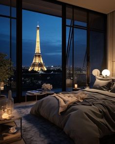 a bedroom with a view of the eiffel tower in paris, france at night