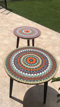 two mosaic tables sitting on top of a patio