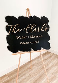 a black and gold wedding sign on an easel with the words, the clarks