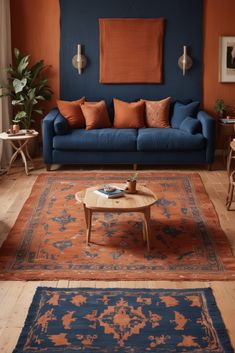 a living room with blue couches and rugs on the floor, orange walls