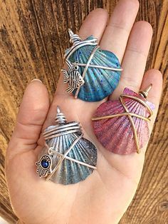 three seashells are sitting in the palm of someone's hand