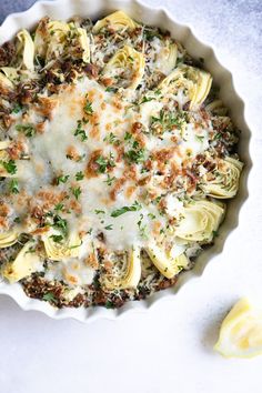 a white bowl filled with pasta covered in cheese and parmesan