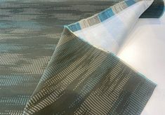 a close up view of a blue and grey patterned wallpaper on a white surface