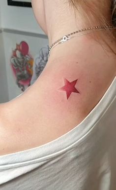 a woman with a red star tattoo on her back shoulder