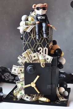 a black and gold clock made out of money with a man sitting on top of it