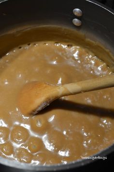 a wooden spoon stirring some food in a pot