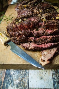 a large steak on a cutting board with a knife