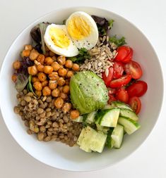 a green plate topped with eggs, broccoli and other foods on top of a white table