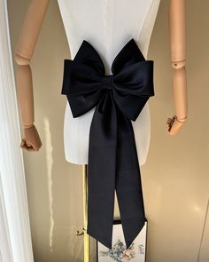 a mannequin with a black bow on it's back and white top