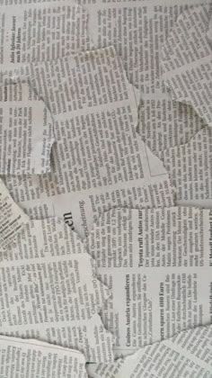 many pieces of newspaper are scattered on top of each other