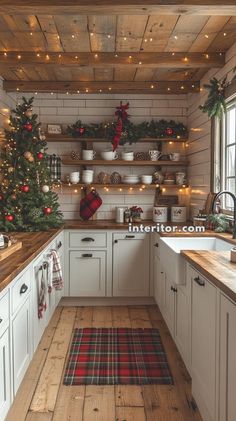 a kitchen decorated for christmas with lights on the ceiling and wooden flooring, white cabinets and open shelving