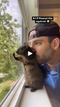 a man is holding a small rodent in his mouth