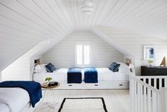 a bedroom with two beds and white walls