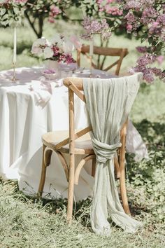 a table set up with two chairs and a white table cloth draped over the chair