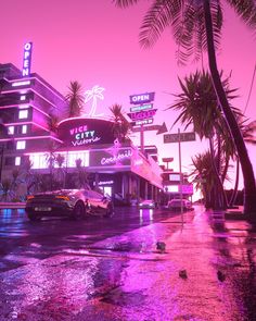 cars parked on the street in front of a building with neon lights and palm trees