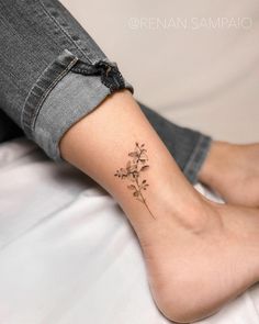 a woman's foot with a small flower tattoo on her left side calfocks