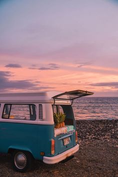 an old vw bus parked on the beach at sunset with its roof open and pineapples in the trunk