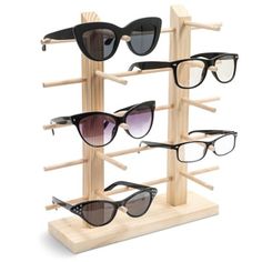 four pairs of sunglasses are on display in a wooden rack with multiple frames and one pair is