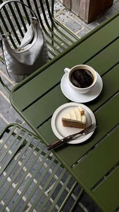 a piece of cake on a plate next to a cup of coffee and a teapot