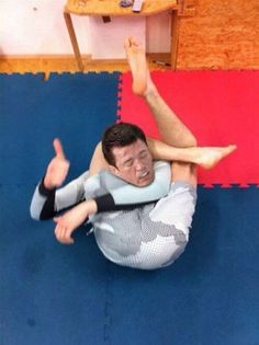 a man laying on top of a blue mat