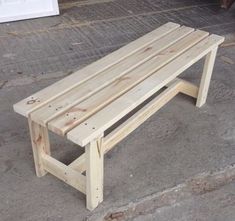 a wooden bench sitting on top of a cement floor