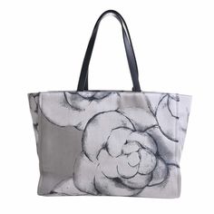 a black and white bag with a large flower on the front, sitting in front of a