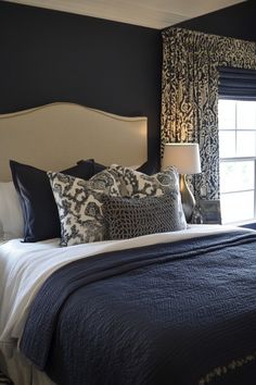 a bed with blue and white pillows in a bedroom