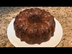 a bundt cake sitting on top of a white plate next to a granite counter