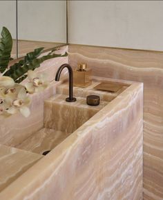 a bathroom sink with marble counter top and gold faucet