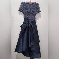 Very Fashionista Vibes!!!; Brand: R&M Richards; Size: 10p; Nwt Never Been Used; Gorgeous Evening Dress; Color: Charcoal But Looks Like Navy Blue W/Sequin Embellished; Skirt Lays High To Long As Shown In Pic;Comes With A Detachable Belt Bow; Inner Lining On Top As Shown In Pic; Zipper In Perfect Condition; So Much Prettier In Person! ; Very Classy Look; Perfect Dress For A Fashionista!! ***Fast/Next Day Shipping! *** Blue Knee-length Mother Of The Bride Dress For Evening, Blue Short Sleeve Dress For Party Season, Spring Blue Short Sleeve Mother Of The Bride Dress, Blue Short Sleeve Party Dress, Blue Short Sleeve Dress For Party, Blue Short Sleeve Evening Dress, Spring Evening Short Sleeve Mother Of The Bride Dress, Blue Short Sleeve Cocktail Dress, Navy Evening Dresses