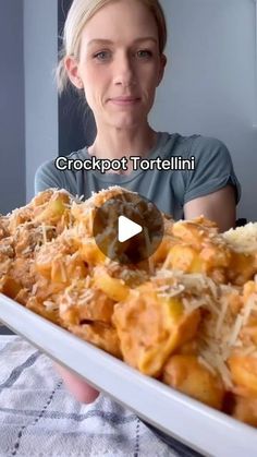 a woman is holding a platter full of food