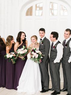 a group of people standing next to each other in front of a white door wearing suits and ties