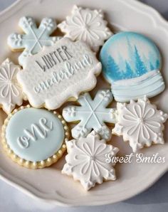 some cookies that are on a plate with snowflakes and other things in the background