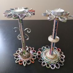 two decorative candlesticks made out of rolled up paper and colored pencils are sitting on a table