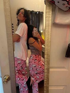 a woman taking a selfie in the mirror while wearing hello kitty pajama pants