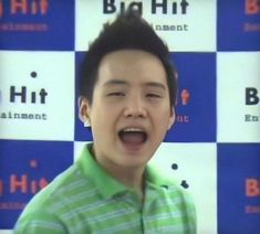 a young man with his mouth open in front of a blue and white wall background