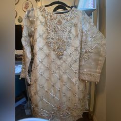 A Beautiful Gold Wedding Dress. Perfect For The Bride Or Bridal Party. Bodice Is Hand Beaded And Sewn With Paisley Motifs Throughout. The Shirt Is Lined But The Sleeves Are Not. The Bust Size Is 36n Inches, Sleeves Are 20-21 Inches, Waist Is 30-32 Inches And Elastic And The Gharara Pant Length Will Fit Anyone Who Is 5’2-5’6”. It Comes With A Dupatta And Long, Flowy Gharara Pants. All Thread Work Is Lined And Overlocked. Brand New And Unworn. Note: Any Defects Not Mentioned But Visible In The Pic Gharara Pants, Wedding Dress Color, Paisley Motifs, Gold Wedding Dress, Colored Wedding Dresses, Thread Work, Size 6 Dress, Pant Length, Hand Beading