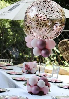 the table is set with pink and white balloons