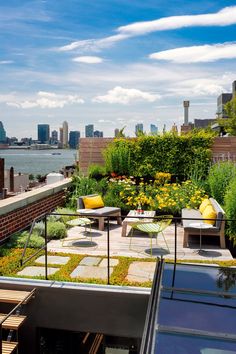 a rooftop garden with benches, tables and plants on the roof terrace overlooking the city