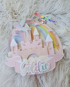 a close up of a paper cut out of a castle with a rainbow on top